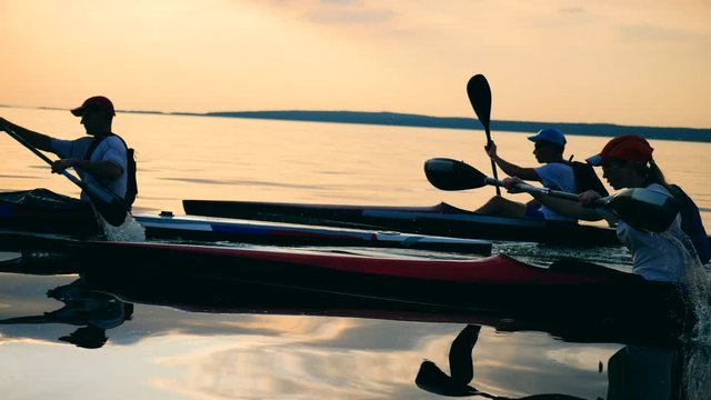 Paddlers are sailing across the lake in canoes