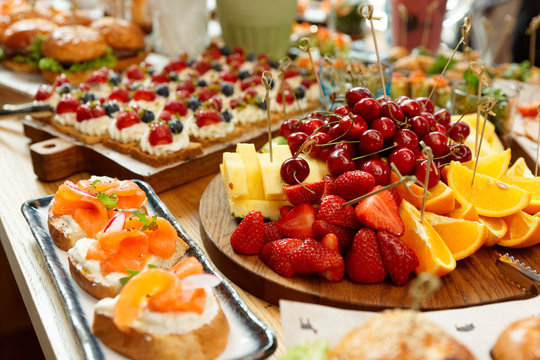 Fruits, fish snacks and dessert on catering table