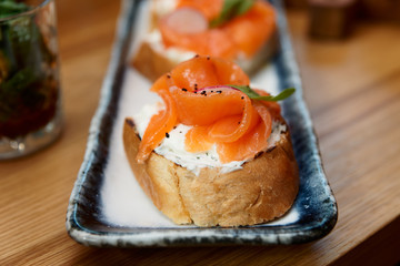 Salmon slices and creamy cheese on bread, set of bruschettas