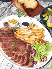 Rib eye steak with vegetables on white plate