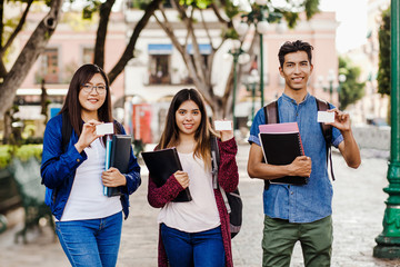 latin students holding a card, hispanic group of friends in Mexico, Mexican young people.