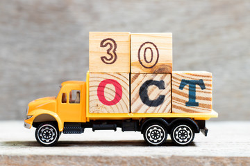 Truck hold letter block in word 30oct on wood background (Concept for date 30 month October)