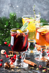 Mulled wine and mulled cider. Hot winter drinks and cocktails for christmas or new year's eve in glass mugs with spices and citrus fruit