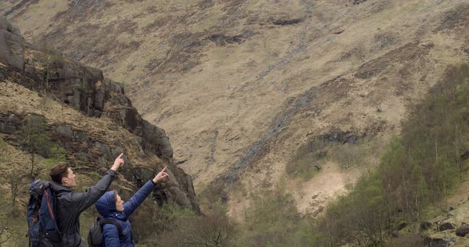 4K Father and Son at the Glen Coe Scottish Mountains in Scotland. Family Hikers pointing at Hills in a Natural Summer Travellers Tourist Destination in Remote Britain.