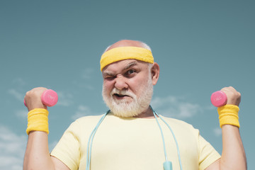 Senior man lifting weights. Health club or rehabilitation center for elderly aged pensioner. Senior...