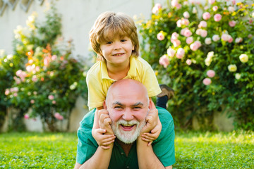 Cute boy with dad playing outdoor. Happy family Grandson hugs his grandpa on holiday. Happy...