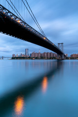 View on Williamsburg Bridge and Downtown Manhattan on a cloudy morning with long exposure