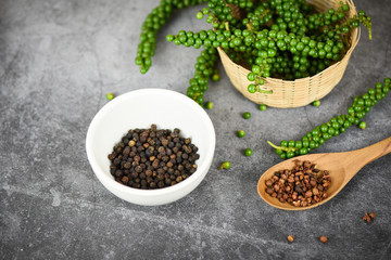 peppercorns on basket and dark background - fresh green peppercorn and black pepper seed on white cup for ingredients cuisine thai food herbs and spices