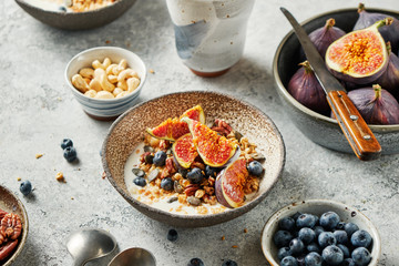 Cereal breakfast with fresh berries, seeds and figs in bowl.