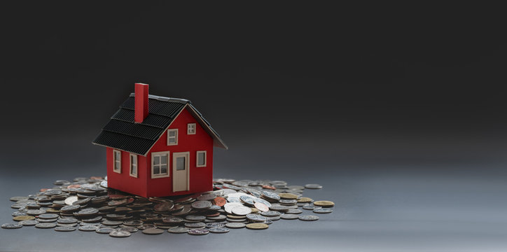 Real estate and property investment concept : small house model on stack of coins
