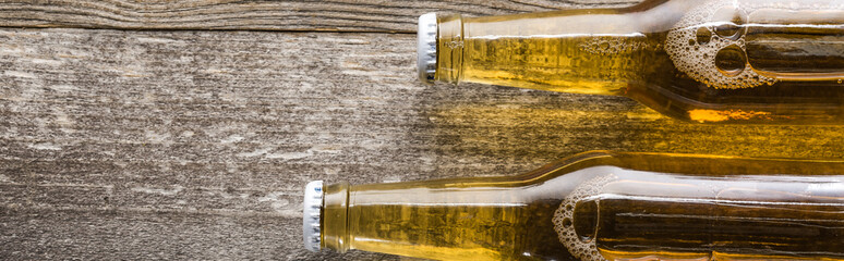 top view of beer in bottles on wooden background, panoramic shot