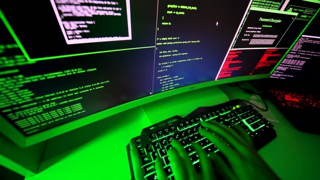 Malicious code on wide screen typed by evil hacker. A black-hat programmer hacking into illegal personal data. Coding ransomware attack to steal personal data in cyber attack.