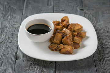 Grilled tofu cheese and soy sauce on a white plate. Soy cheese. Flat lay.