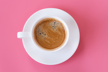 Top view of hot coffee and foam in white cup isolated on pink background and copy space.Coffee menu in the coffee shop or restaurant.