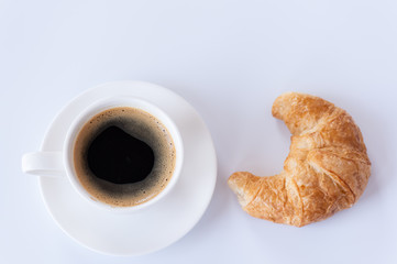 Top view of hot coffee and foam in white cup with croissant isolated on white background and copy space.Coffee menu in the coffee shop or restaurant.