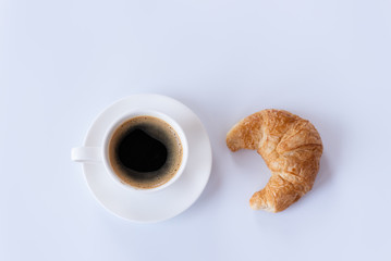 Top view of hot coffee and foam in white cup with croissant isolated on white background and copy space.Coffee menu in the coffee shop or restaurant.