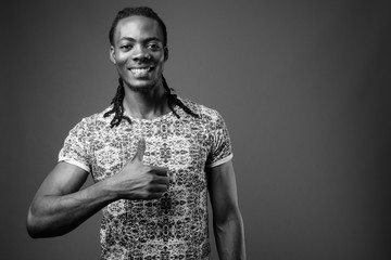 Young handsome African man against brown background