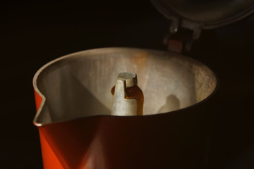 red geyser coffee maker on black background. moka pot