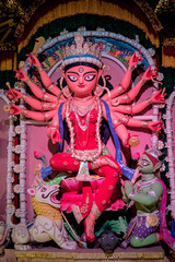 Fototapeta premium Idol of Goddess Devi Durga at a decorated puja pandal in Kolkata, West Bengal, India. Durga Puja is a popular and major religious festival of Hinduism that is celebrated throughout the world.