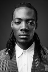 Young handsome African businessman against brown background