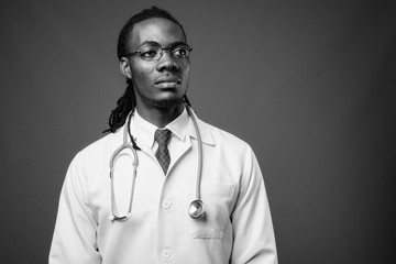 Young handsome African man doctor against brown background