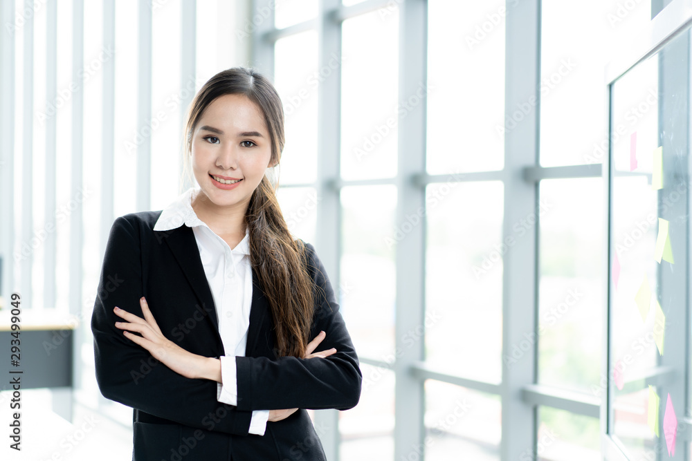 Wall mural portrait of beautiful and smart asian businesswoman in formal suit standing beside window close up. 