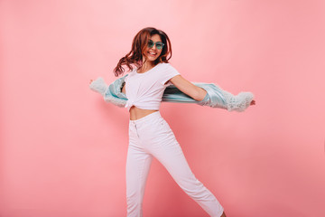  Inspired positive girl in white sneakers dancing on pink background. Gorgeous young female model...
