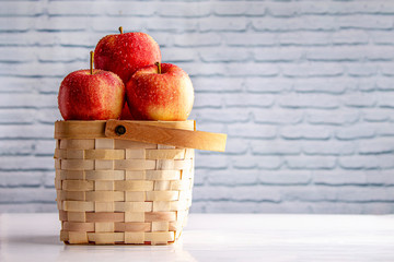 apples in a basket on wooden table