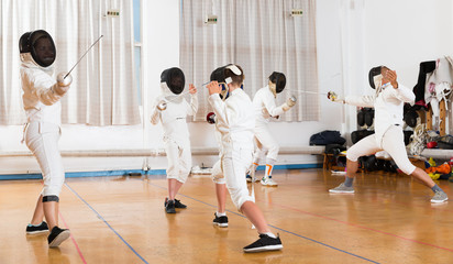 Boys with adults practicing fencing techniques