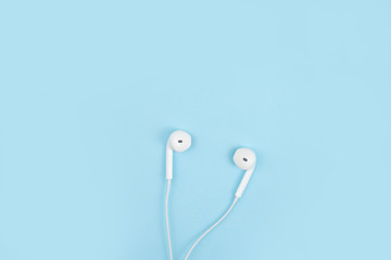 Earphone on a blue background. Close up.