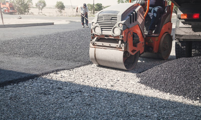 Asphalt roller stacking and pressing hot asphalt.