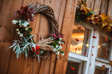 Decorative design window on the terrace. autumn wreath and pumpkins vintage old chest of drawers on wooden rustic background.