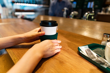 熱々のコーヒーを持つ女性の手