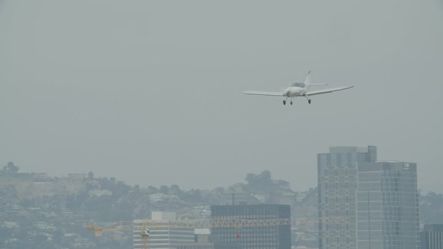 Small generic private propeller airplane preparing for landing, no tail or identification number. 60 FPS Slow Motion, 4K RAW graded footage