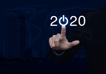 Businessman pressing 2020 start up business flat icon over world map, modern city tower and skyscraper, Business happy new year cover, Elements of this image furnished by NASA