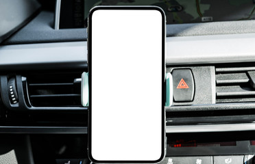 Smartphone in a car use for Navigate or GPS. Driving a car with Smartphone in holder. Mobile phone with isolated white screen. Blank empty screen. copy space. Empty space for text. modern car interior