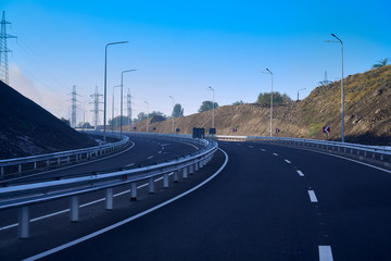 Landscape with rocks, sunny sky with clouds and beautiful asphalt road