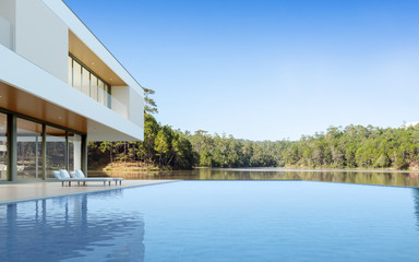 Fototapeta premium Perspective of luxury modern house with swimming pool in day time on forest lake background, Idea of minimal architecture design. 3D rendering
