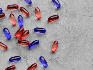 Red and blue pills isolated on gray background with copy space. Concept of pharmacology,...