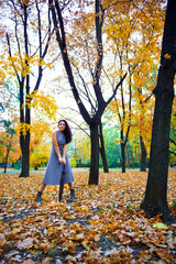 woman posing with umbrella and autumn leaves in city park, outdoor portrait