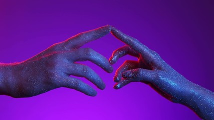 Neon 70s style vivid light. Two male and female hands in sparkles tenderly touched finger to finger, then letting go of love, splitting relationship by disjoining hands