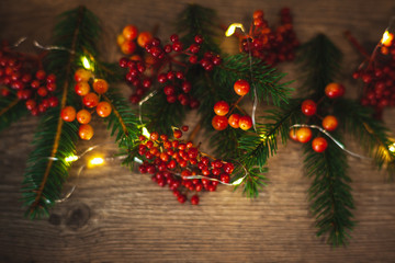 Christmas blank for your advertisement, banner. Berries and spruce branches on a wooden background