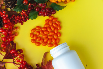 Autumn composition with vitamins and berries. Coenzyme Q 10 pills laid out in the form of a heart. Images for banner, poster.