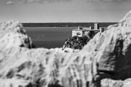 Gulf of Trieste. High cliffs Between boats, karst rocks and ancient castles. Black and white. Duino. Italy