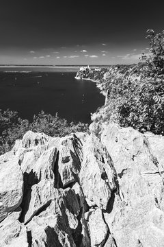 Gulf of Trieste. High cliffs Between boats, karst rocks and ancient castles. Black and white. Duino. Italy