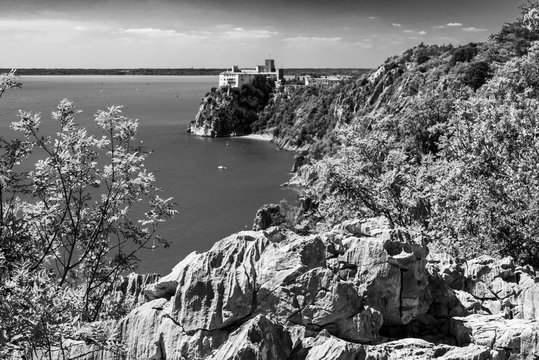 Gulf of Trieste. High cliffs Between boats, karst rocks and ancient castles. Black and white. Duino. Italy