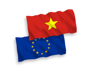 National vector fabric wave flags of European Union and Vietnam isolated on white background. 1 to 2 proportion.