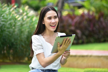 Women using tablet filling happy smile to shopping online at city park