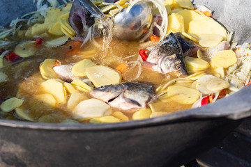 Prepare fish soup in a pot. On the street at the stake.