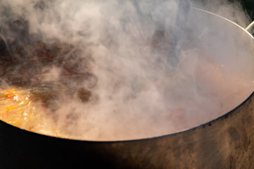 Steam from the pan is cooking on the street.